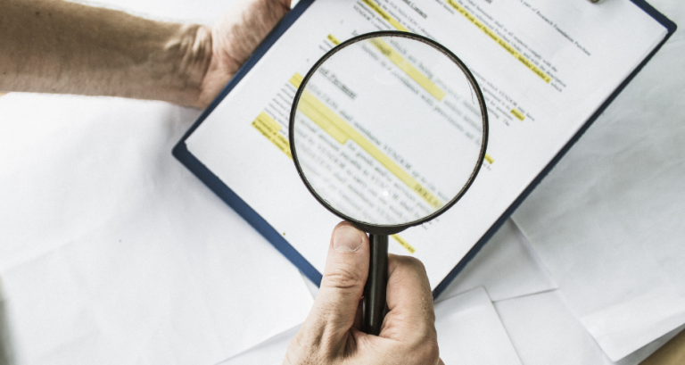 A magnifying glass looking at some legal jargon. Demystifying insurance terms is one way to take control of your finances!