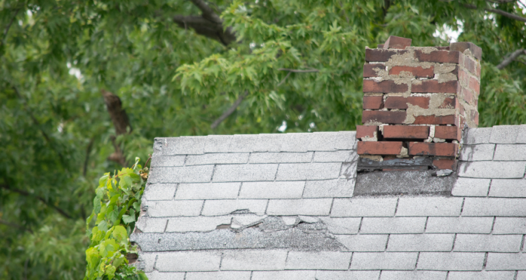 An aging roof impacts a home's worth and ability to withstand weather events like wind and hail. This old roof has broken shingles and a crumbling chimney.